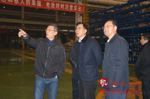 汉川机床总经理杜立群（左）向汉中市委书记魏增军（中）介绍公司生产的大型数控机床新产品