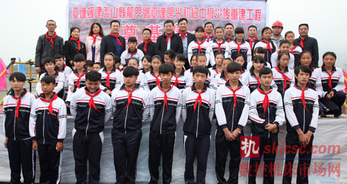 图四 参加“龙门乡台达阳光初级中学”奠基仪式的领导嘉宾与同学们合影留念